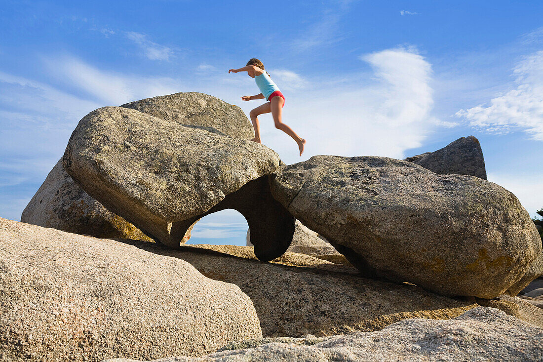 Girl climbing on rocks, Palombaggia, Corsica, France