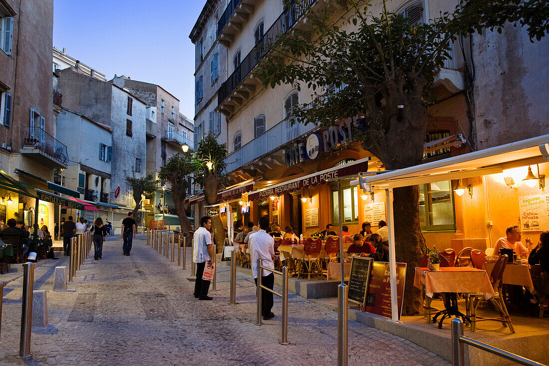 Straßenszene mit Restaurants zur blauen Stunde in der Altstadt von Bonifacio, Südküste, Korsika, Frankreich, Europa