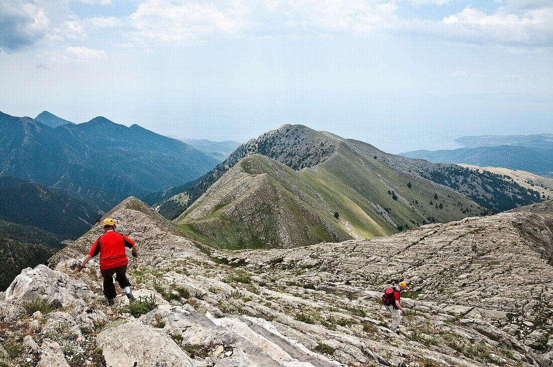 Walkers descending a ridge just below the summit of Kokinovouni in the Taygetos mountains, Mani Peninsula, Southern Peloponnese, Greece