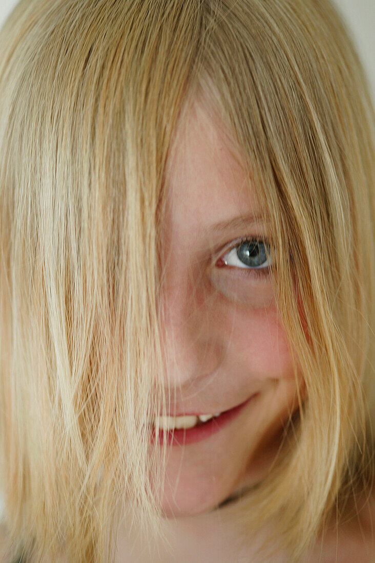 Mädchen (12 Jahre) mit Haaren vor dem Gesicht