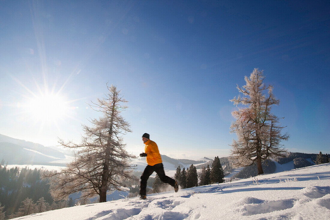 Mann joggt im Schnee, Steiermark, Österreich
