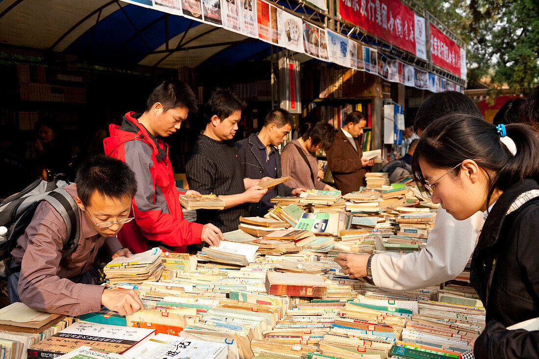 Book market in Ditan Park, Chinese people browsing through books, Beijing, People's Republic of China