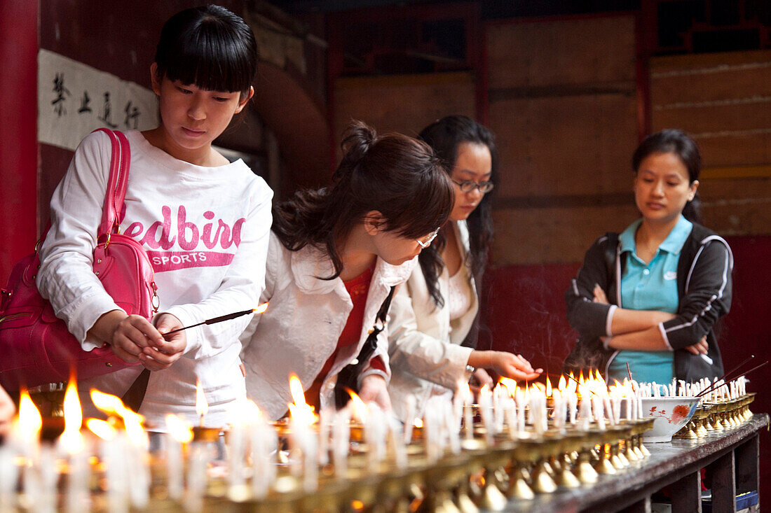 Öllampen und Butterlampen, Frauen zünden Kerzen an, Luohan Tempel, buddhistischer Tempel im Stadtzentrum, Chongqing, VR China