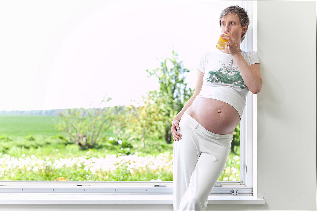 Schwangere Frau trinkt ein Glas Saft, Rerik, Mecklenburg-Vorpommern, Deutschland