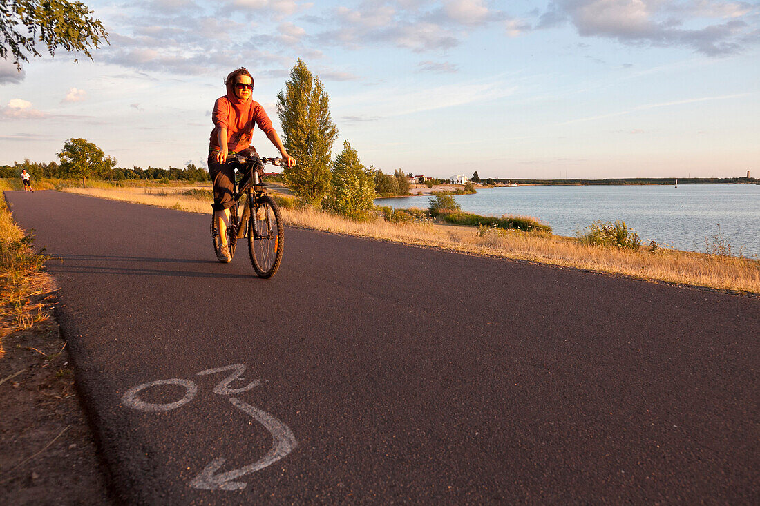 Female cyclist near Cospuden Lake, Leipzig, Saxony, Germany