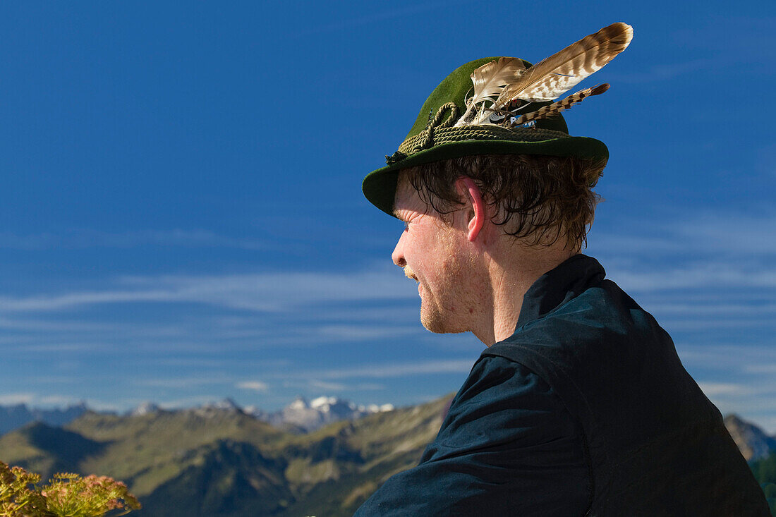 Bayer mit federngeschmücktem Trachtenhut auf dem Gipfel des Schildenstein in den Alpen, Oberbayern, Bayern, Deutschland, Europa