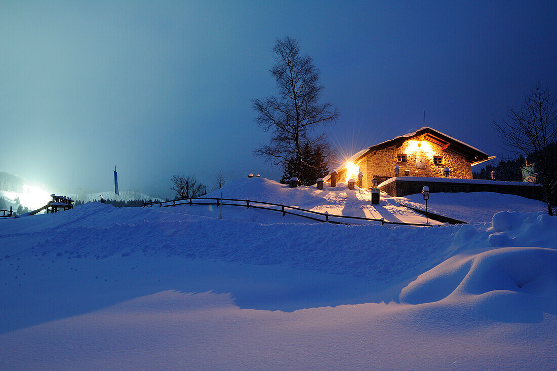 Illuminated hut on snow-covered hill, Albert-Link-Huette, Spitzing area, Bavarian Alps, Upper Bavaria, Bavaria, Germany, Europe