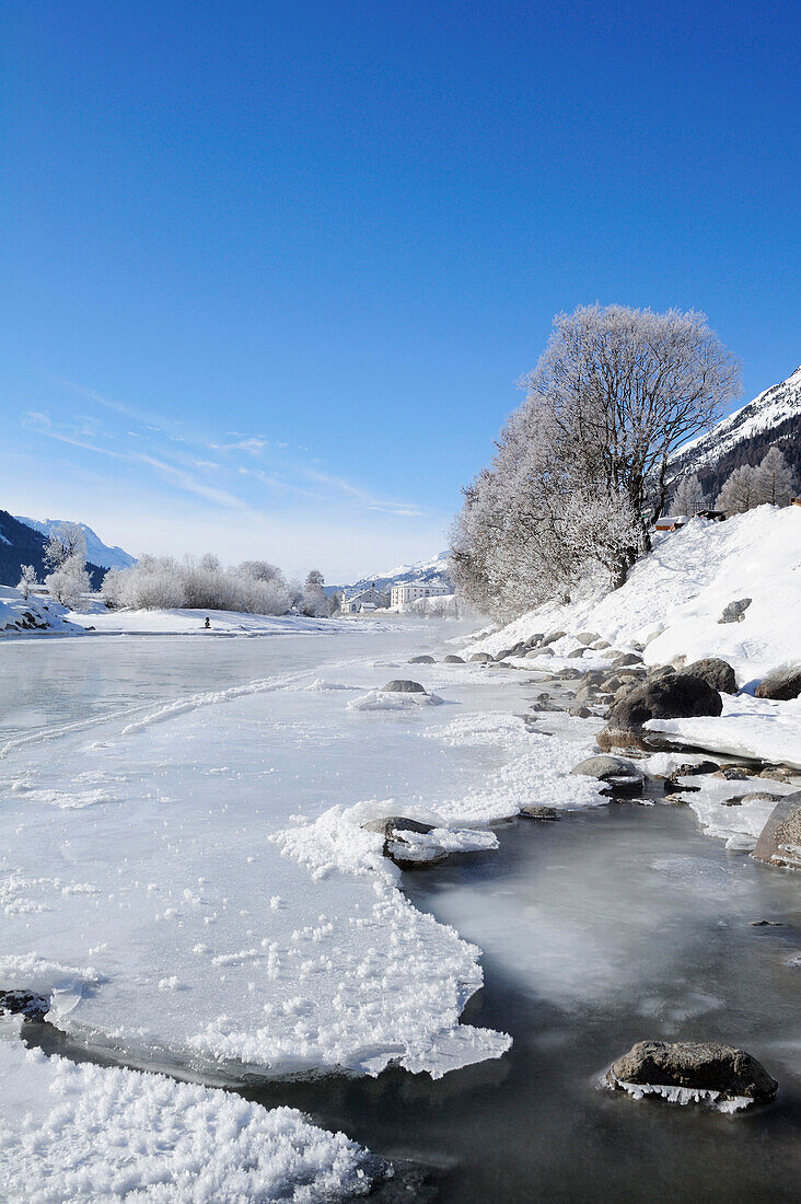 River Inn with ice-covered bank and La Punt-Chamues-ch in background, La Punt, Upper Engadin, Engadin, Grisons, Switzerland, Europe