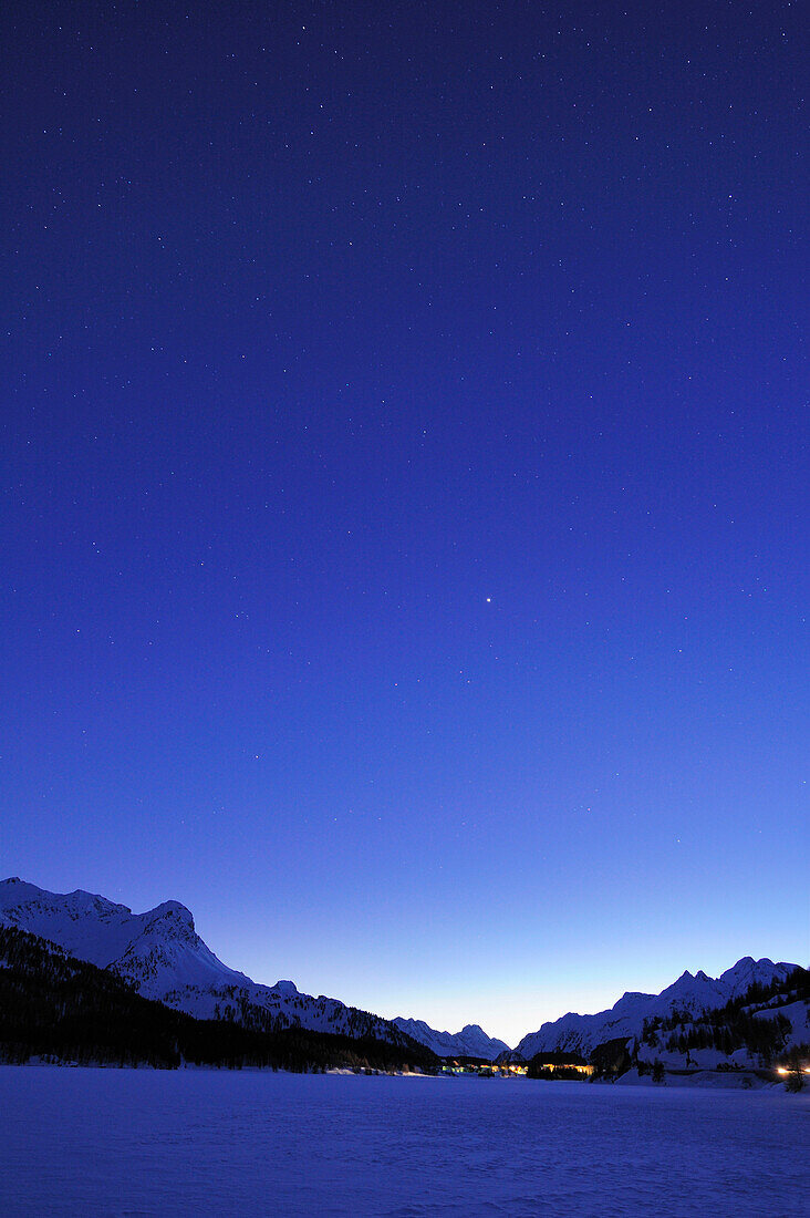 Night sky above snow-covered lake Silser See, with view to Malojapass, lake Silser See, Bernina range, Upper Engadin, Engadin, Grisons, Switzerland, Europe