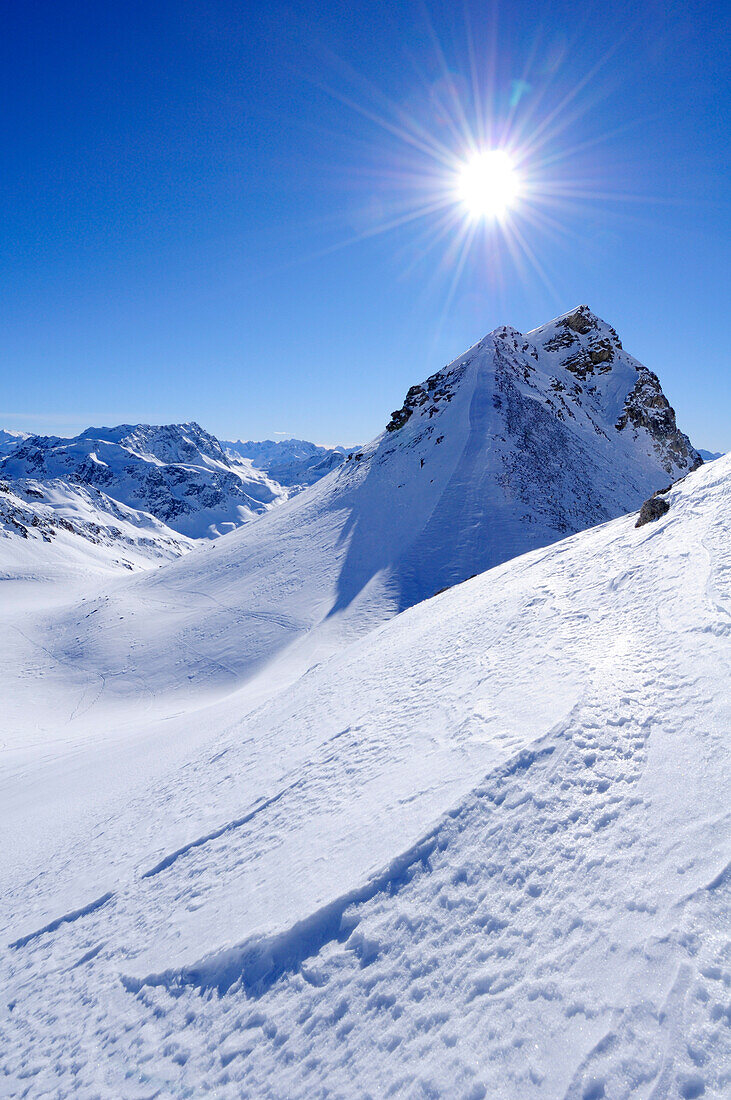 Sun above Corn Alv in winter landscape, Julierpass, Albula range, Upper Engadin, Engadin, Grisons, Switzerland, Europe