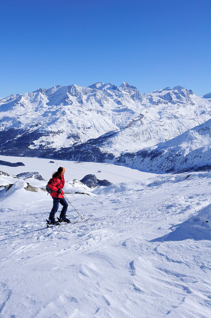 Frau auf Skitour blickt auf Berninagruppe und Silser See, Piz Grevasalvas, Albulaalpen, Oberengadin, Engadin, Graubünden, Schweiz, Europa