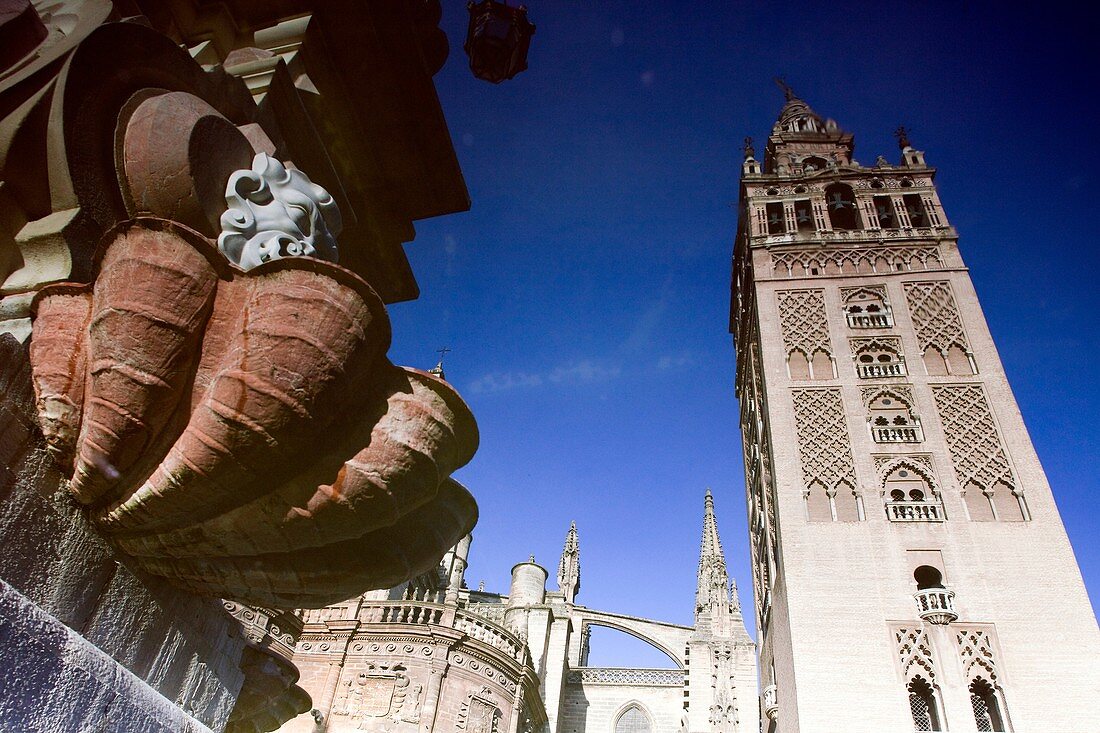 The Giralda Tower reflected on the fountain of Virgen de los Reyes square, Seville, Spain