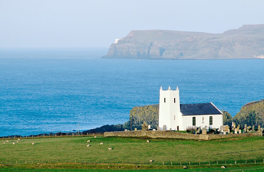Ballintoy parish church at Ballintoy Harbour near Bushmills on County Antrim coast road Rathlin Island behind Northern Ireland