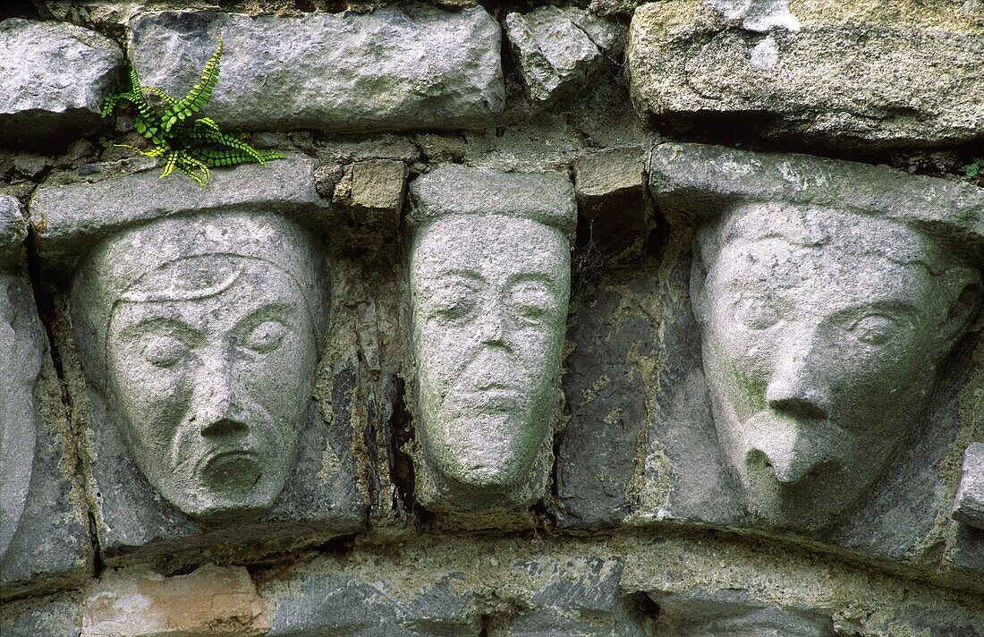 Carved stone human and animal heads on Romanesque door arch of ancient monastic church at Dysert O'Dea, County Clare, Ireland