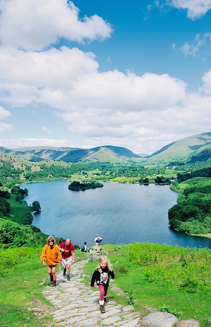 Walkers on Loughrigg Fell above Grasmere valley in the Lake District National Park Home of poet Wordsworth Cumbria, England
