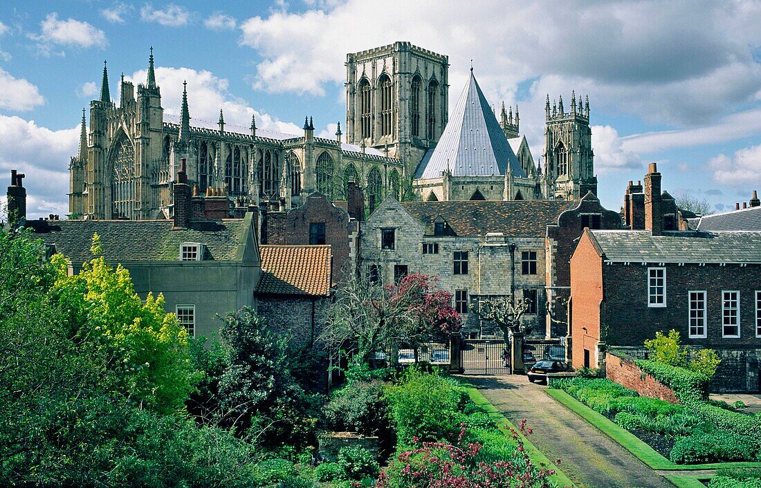 York Minster medieval cathedral behind the Treasurers House seen from the city walls in the city of York, Yorkshire, England UK