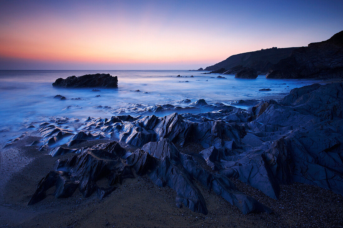 Rocky beach and seascape at sunset, Gunwalloe, Cornwall, UK - England