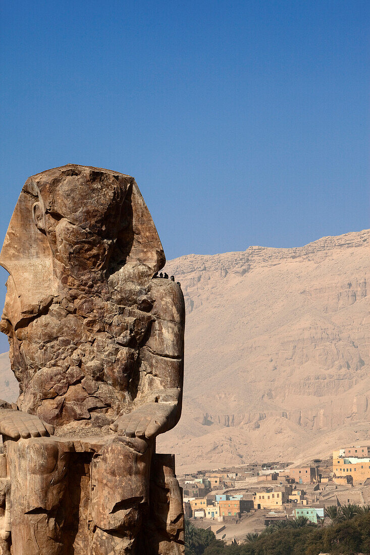 Coloss of Memnon with a nubian village, Luxor, ancient Thebes, Egypt, Africa