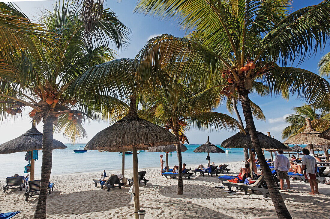 Palmen und Menschen am Strand des Beachcomber Hotel Paradis &amp; Golf Club, Mauritius, Afrika