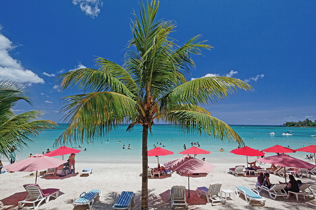 Palmen und Menschen am Strand im Sonnenlicht, Pereybere, Mauritius, Afrika