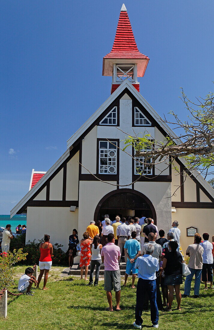 Menschen vor der Kapelle Notre Dame Auxiliatrice unter blauem Himmel, Cap Malheureux, Mauritius, Afrika