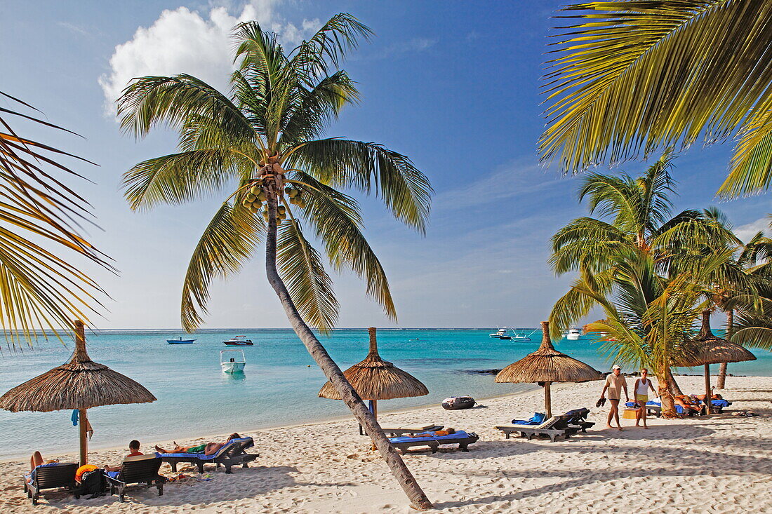 Palmen und Menschen am Strand des Beachcomber Hotel Paradis &amp,amp,amp; Golf Club, Mauritius, Afrika