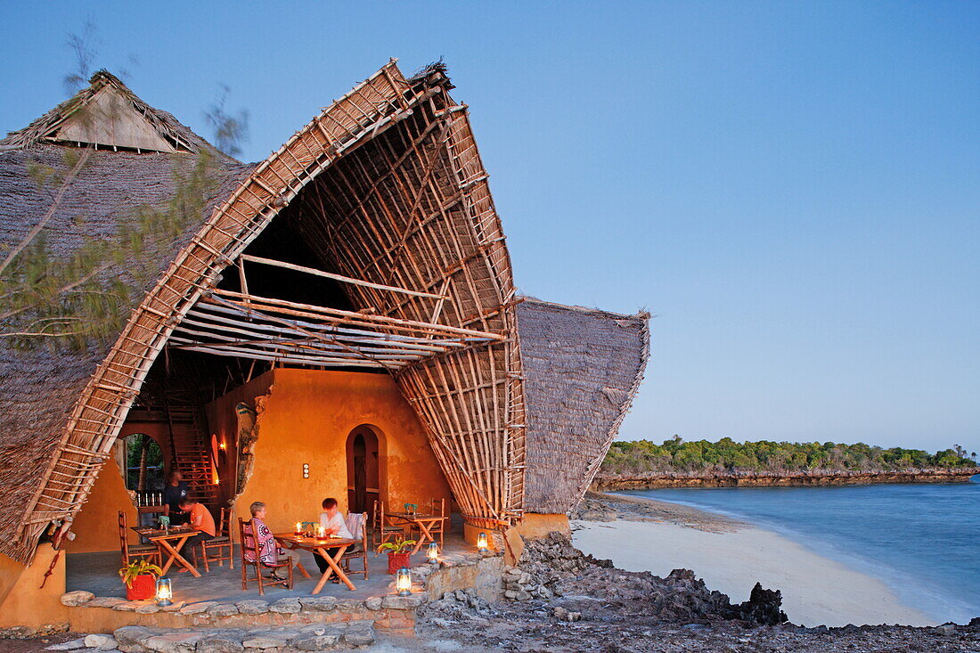 Menschen vor der Chumbe Island Coral Park Lodge in der Abenddämmerung, Restaurant und Besucherzentrum, Chumbe Island, Sansibar, Tansania, Afrika