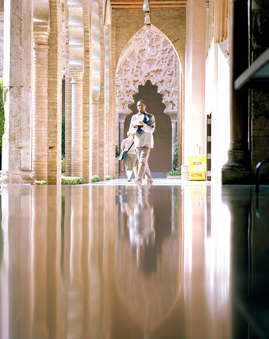 Man walking through the arcades in the Alfjaferia palace, Mudéjar style, UNESCO World Heritage, Saragossa, Aragon, Spain