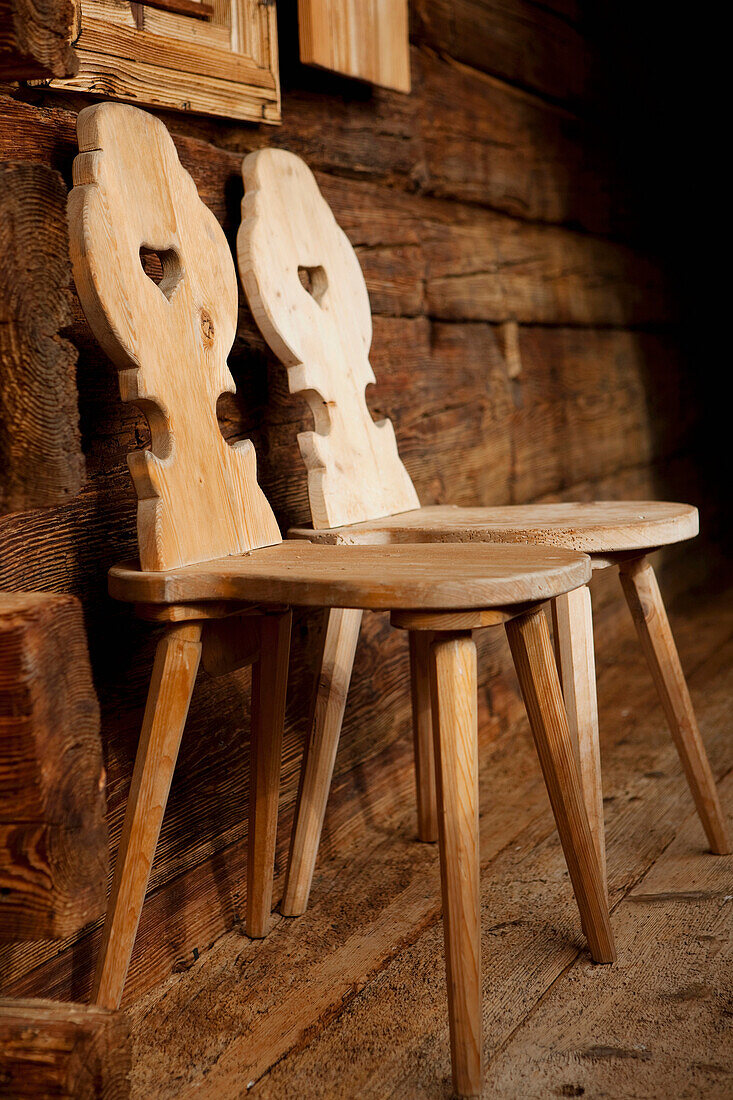 Zwei Stühle, rustikale Holzstühle vor einem Holzhaus, Alm, Tirol, Österreich