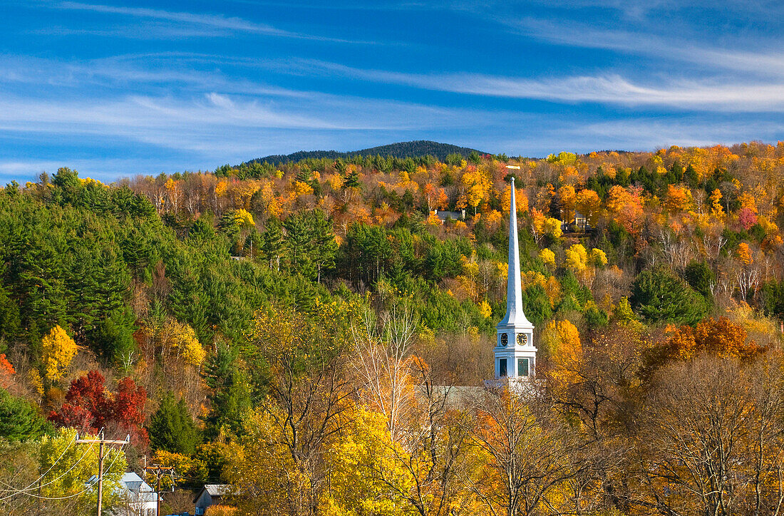 View to chapel over autumn treeline, Stowe, Vermont, USA
