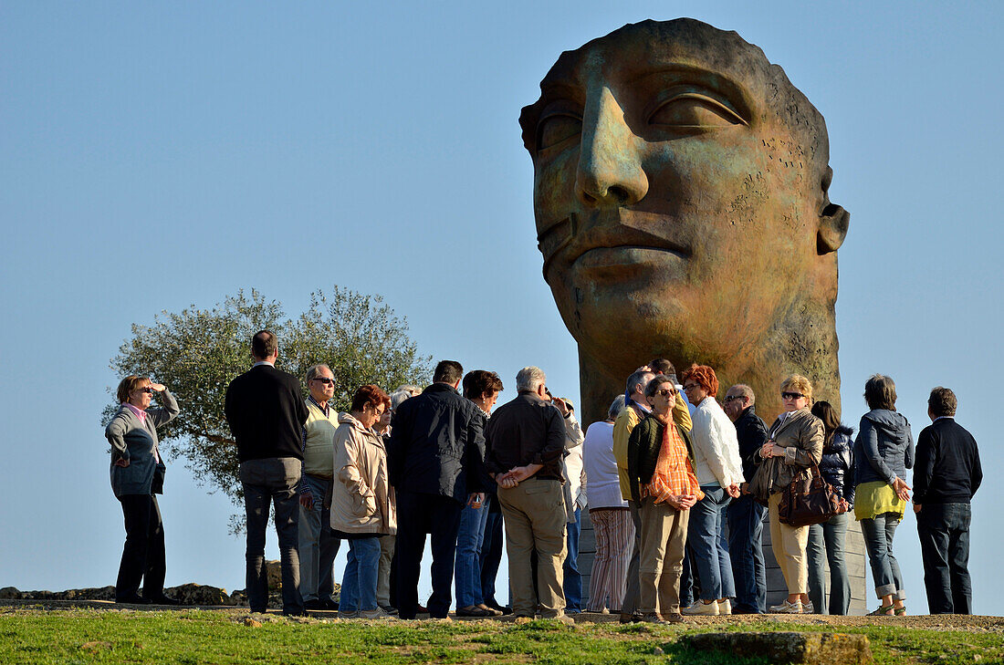 Tourists in front of the sculpture by Igor Mitoraj Valle dei Templi, Agrigento, Sicily, Italy