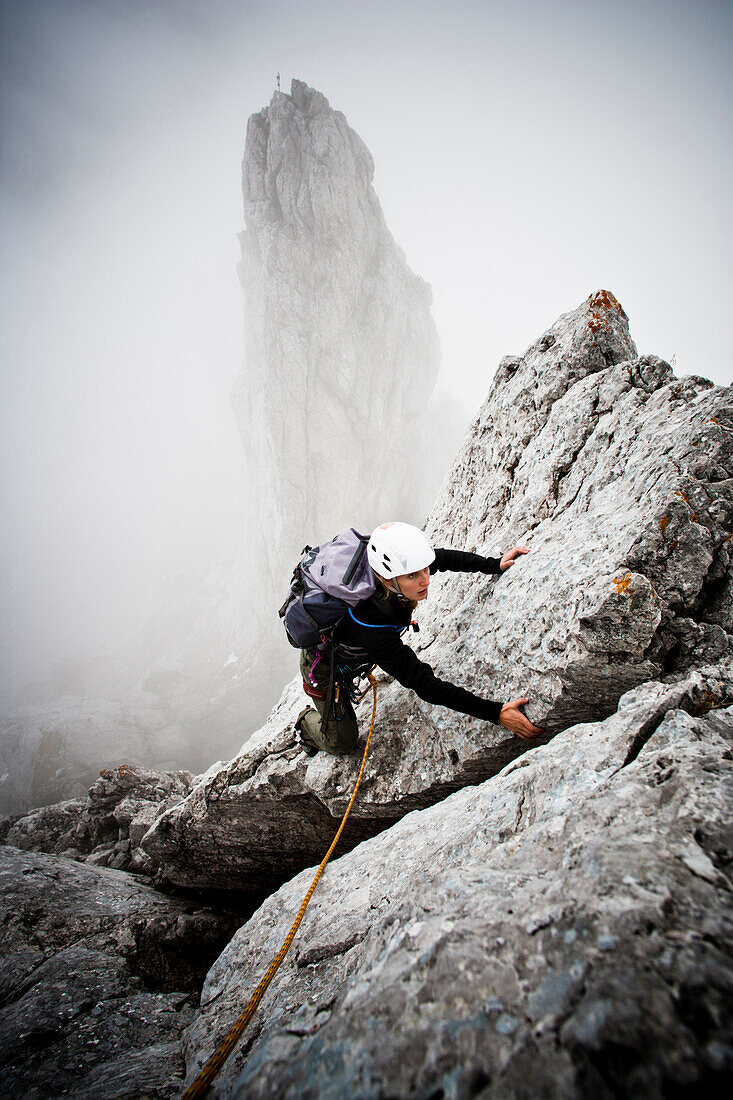 Female mountaineer at Kopftoerlgrat, Kapuzenturm in background, Ellmauer Halt, Kaiser Mountain Range, Tyrol, Austria