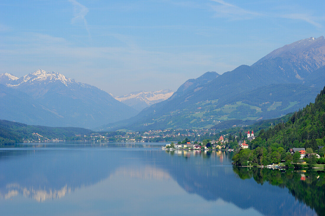 Lake Millstaetter See with convent Millstatt and snow covered mountains in the background, lake Millstaetter See, Carinthia, Austria, Europe