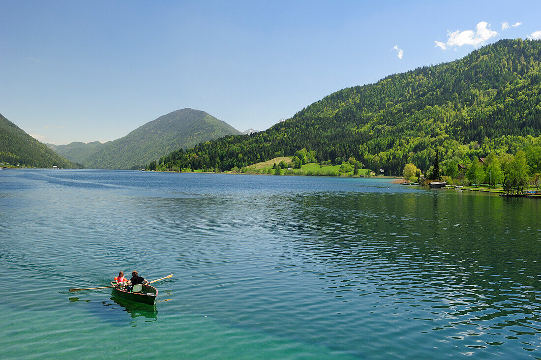 Two persons rowing a boat on lake Weissensee, lake Weissensee, Carinthia, Austria, Europe