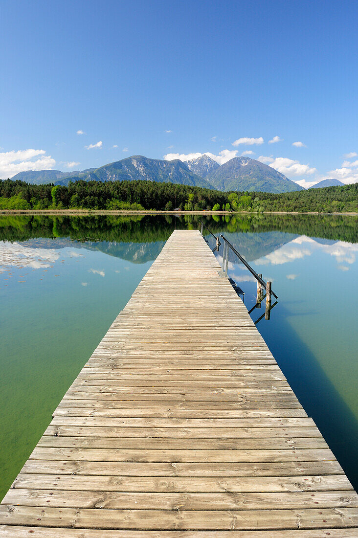 Holzsteg führt in Turnersee, Karawanken im Hintergrund, Turnersee, Kärnten, Österreich, Europa