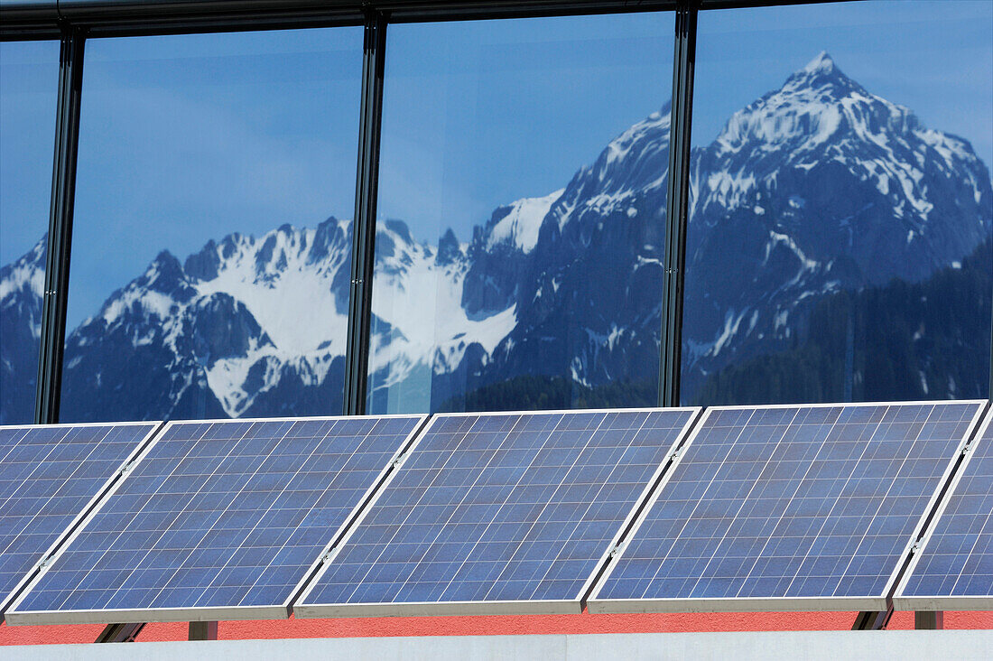 Solar panel on commercial building with windows reflecting mountains, solar plant, photovoltaics, valley of Gailtal, Carinthia, Austria, Europe