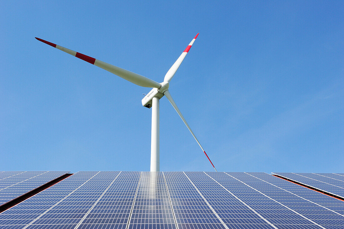 Wind power plant rising above solar panels, Ulm, Baden-Wuerttemberg, Germany, Europe