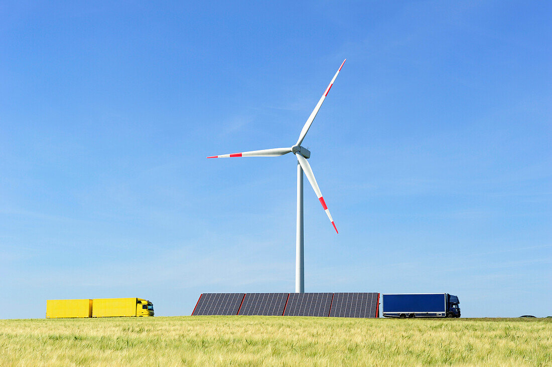 Wind power plant rising above solar panels with corn field in foreground, Ulm, Baden-Wuerttemberg, Germany, Europe