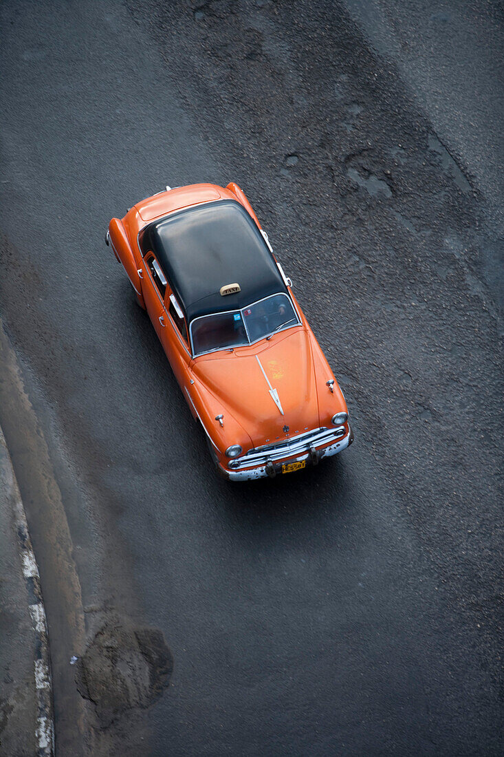 Orangefarbenes amerikanisches Auto fährt als Taxi Oldtimer entlang Malecon Uferpromenade, Havanna, Kuba, Karibik