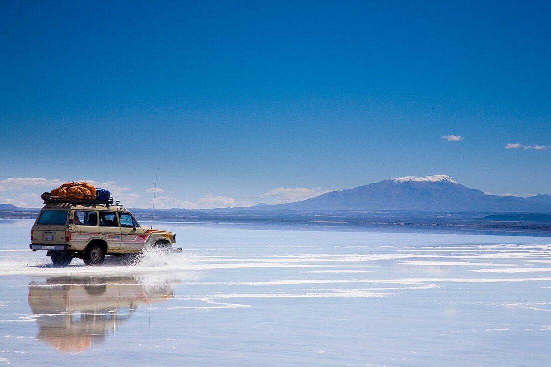 Bolivia, Southern Altiplano, Salar de Uyuni Tourist jeep crossing the Salar de Uyuni salt flat