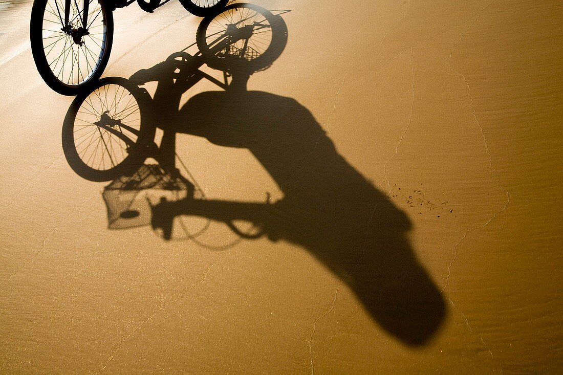 Laos, Si Phan Don Four Thousand Islands, Don Khon Female tourist on a hired bicycle on a sandy beach on the island of Don Knon