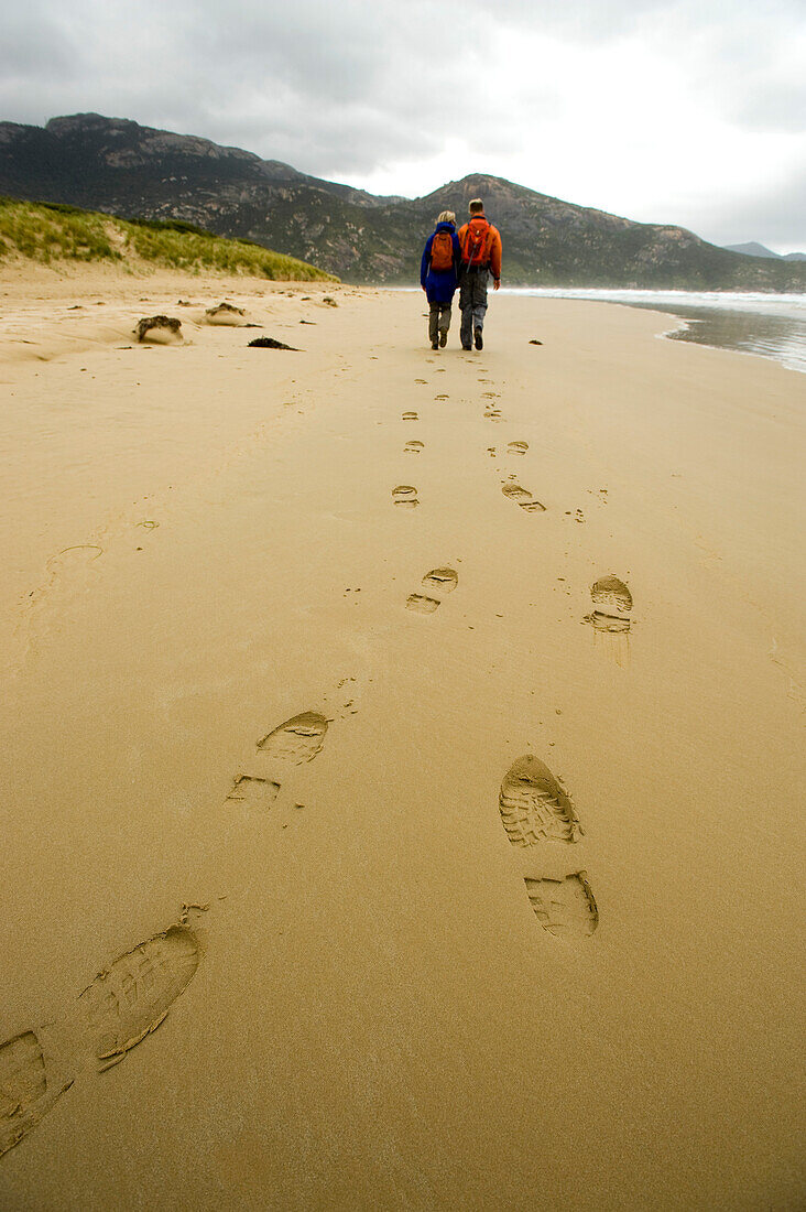 Two hikers walking along Norman Beach, Wilsons Promontory National Park, Victoria, Australia