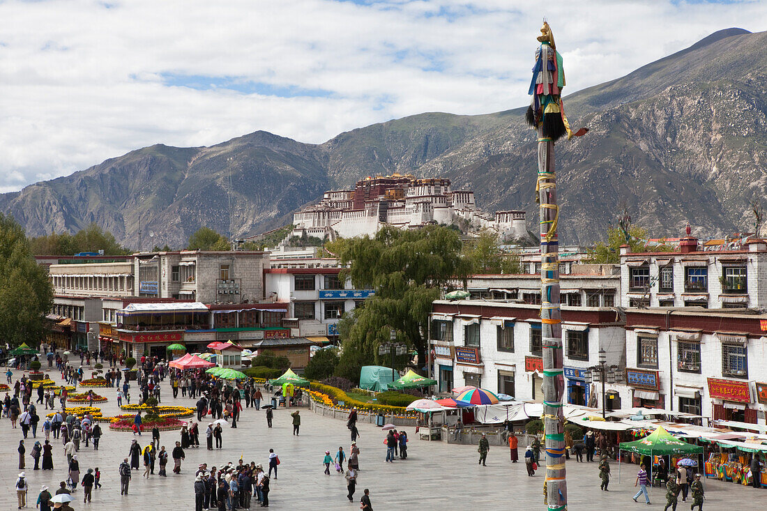 Barkhor Platz mit Pilgern in der Altstadt von Lhasa, Potala Palast im Hintergrund, autonomes Gebiet Tibet, Volksrepublik China