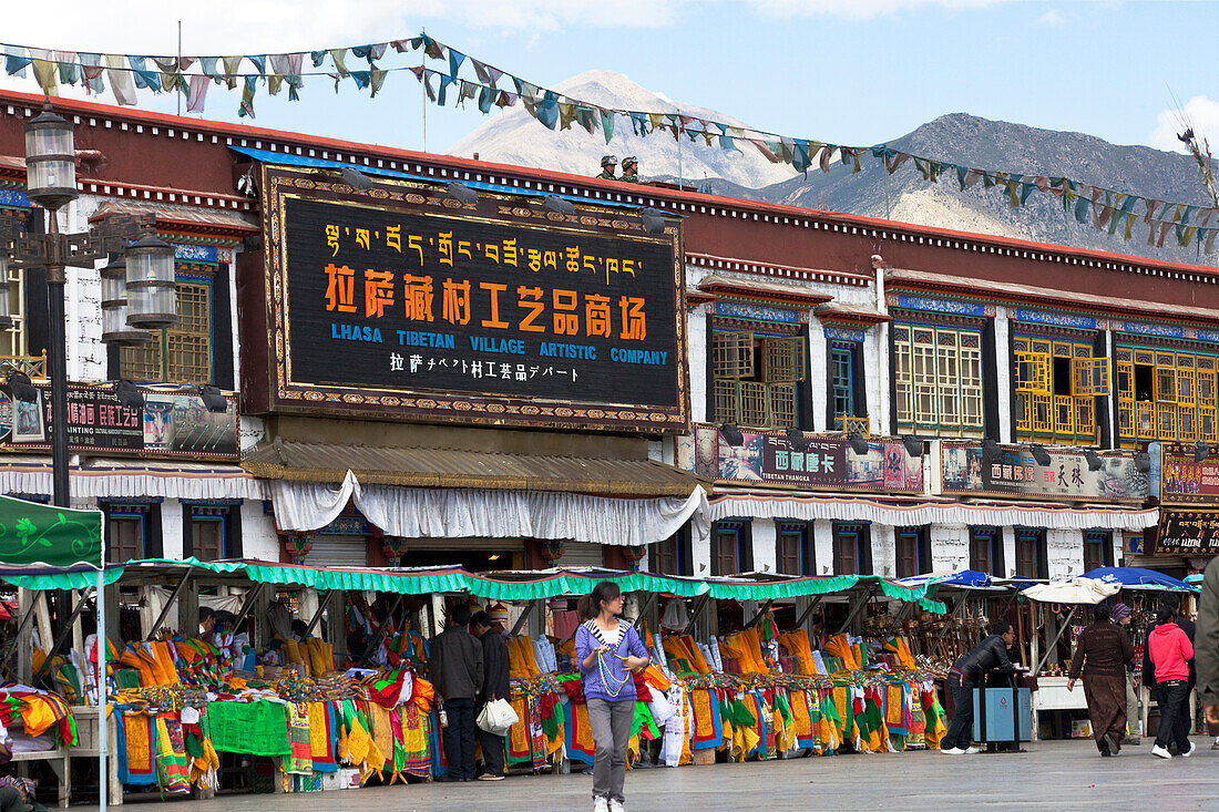 Läden mit Gebetsfahnen am Barkhor Platz in der Altstadt von Lhasa, Potala Palast im Hintergrund, autonomes Gebiet Tibet, Volksrepublik China
