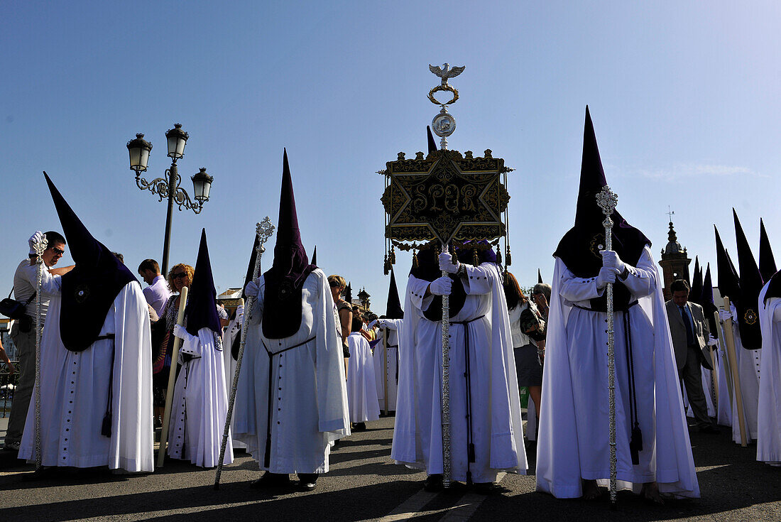 Nazarenos of the brotherhood La Estrella during procession on Palm Sunday, Semana Santa, Triana, Sevilla, Andalusia, Spain, Europe