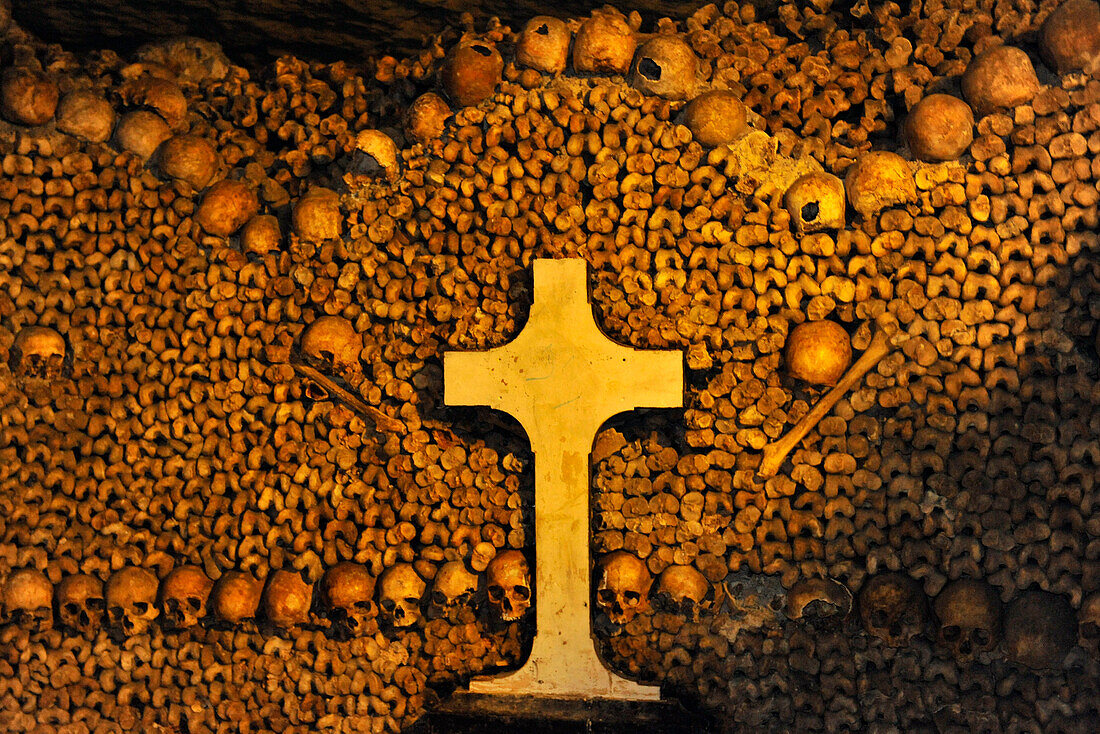 Pile of bones and cross in the catacombs, Paris, France, Europe