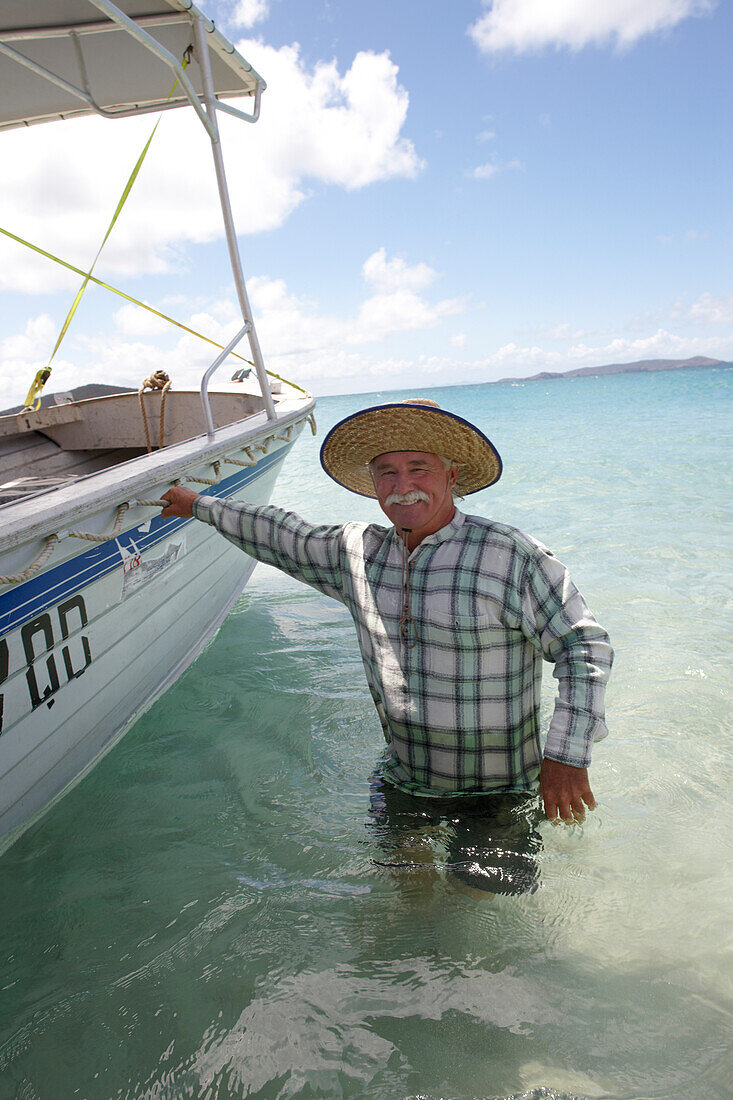 Geoff Mercer, Hotelier und Bewohner von Great Keppel Island, im Wasser an seinem Boot, Great Keppel island, Great Barrier Reef Marine Park, UNESCO Weltnaturerbe, Queensland, Australien