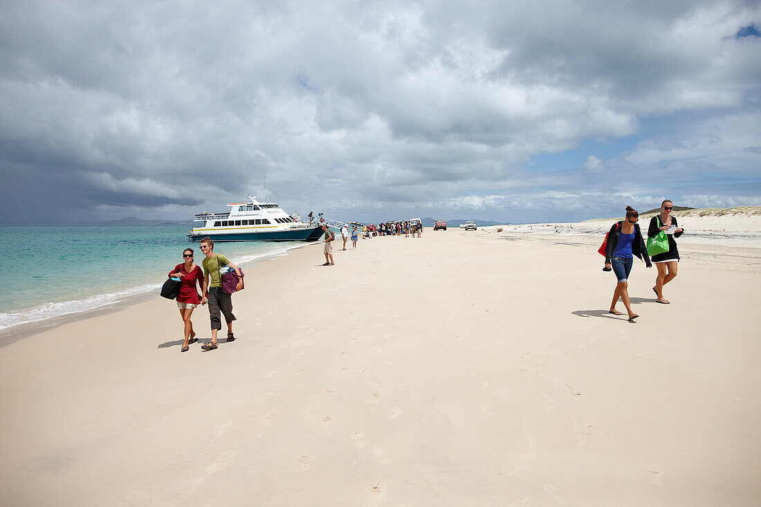 Tourists after arrival on Long beach, southern Great Keppel Island, Great Barrier Reef Marine Park, UNESCO World Heritage Site, Queensland, Australia