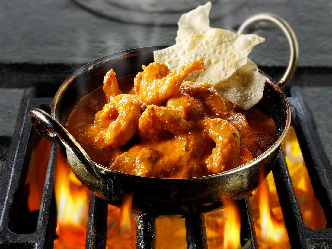 Prawn Makhani curry being cooked over hot charcoals Indian food recipe .