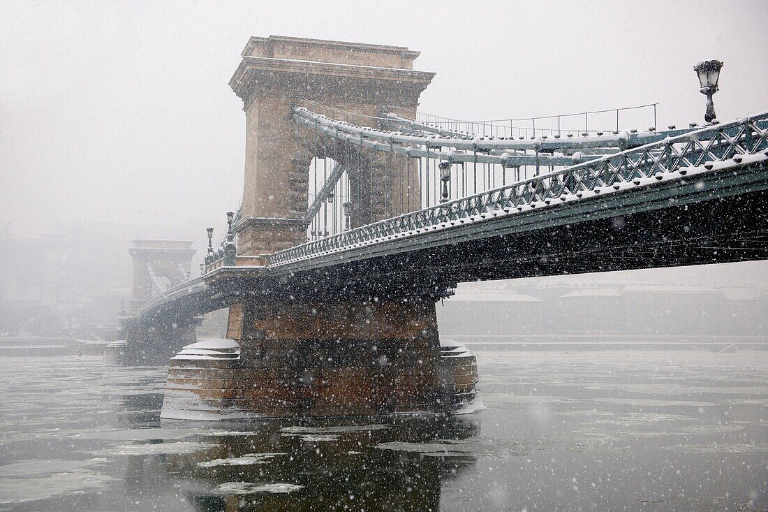 South side of the Szechenyi Lanchid Chain Bridge in the winter snow looking towards the castle district Budapest Hungary.
